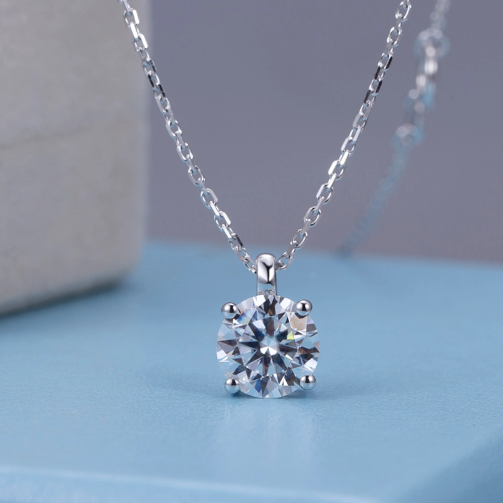 Allison Diamond Drop Necklace by Zomaco displayed on blue table in frontal view, highlighting its elegant design and diamond details
