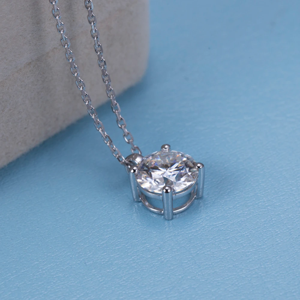 Allison Diamond Drop Necklace by Zomaco viewed from above on blue table, showcasing its intricate design and diamond details